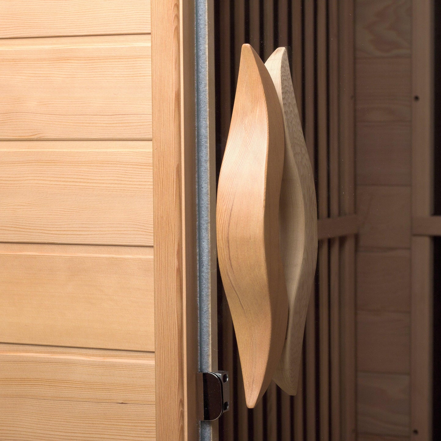 Curved wooden door handles on the Durasage Canadian hemlock infrared sauna